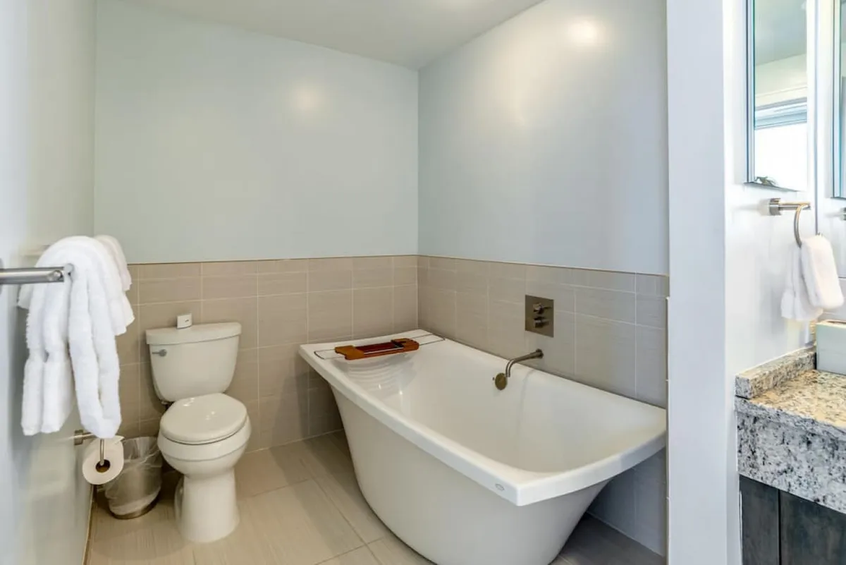 A spa-inspired bathroom featuring a luxurious bathtub, contemporary vanity, and tranquil color palette. The space invites self-care, relaxation, and moments of solitude, echoing high-end finishes and a calming mood.