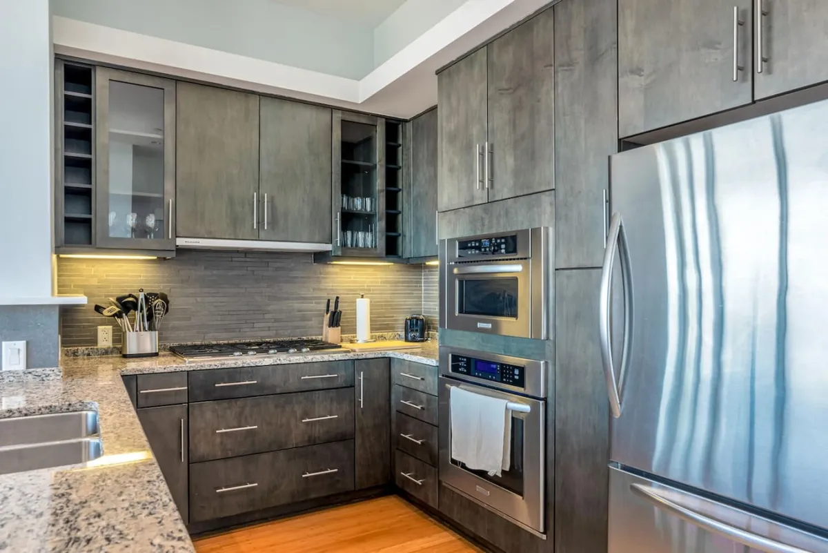 A contemporary kitchen with granite countertops, stainless steel appliances, and sleek cabinetry. The design is both inviting and practical, suitable for intimate dinners or larger celebrations, and emphasizes a refined yet welcoming culinary environment.